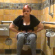 A plump girl takes a shit and a piss while sitting on a toilet in a public restroom. Some sporadic, soft, subtle plops can be heard while she grunts and pushes. About 5 minutes.